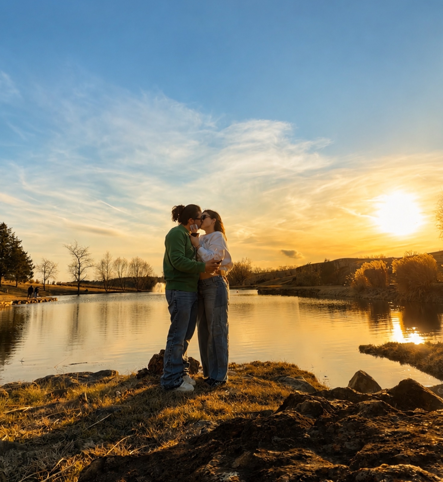 Pareja besándose frente a un lago al atardecer — foto real